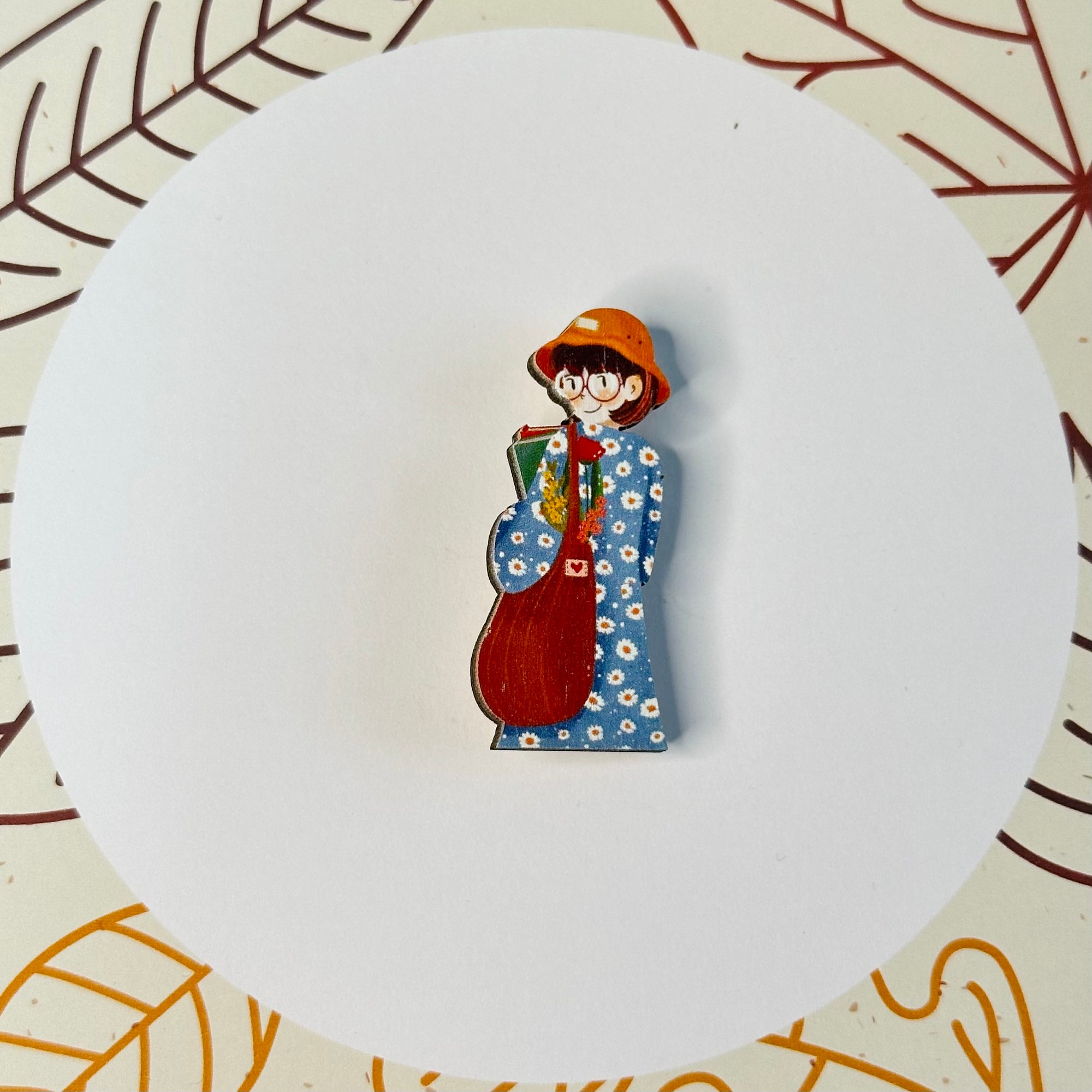 A girl in a blue dress, daisies and a bag with a wooden brooch