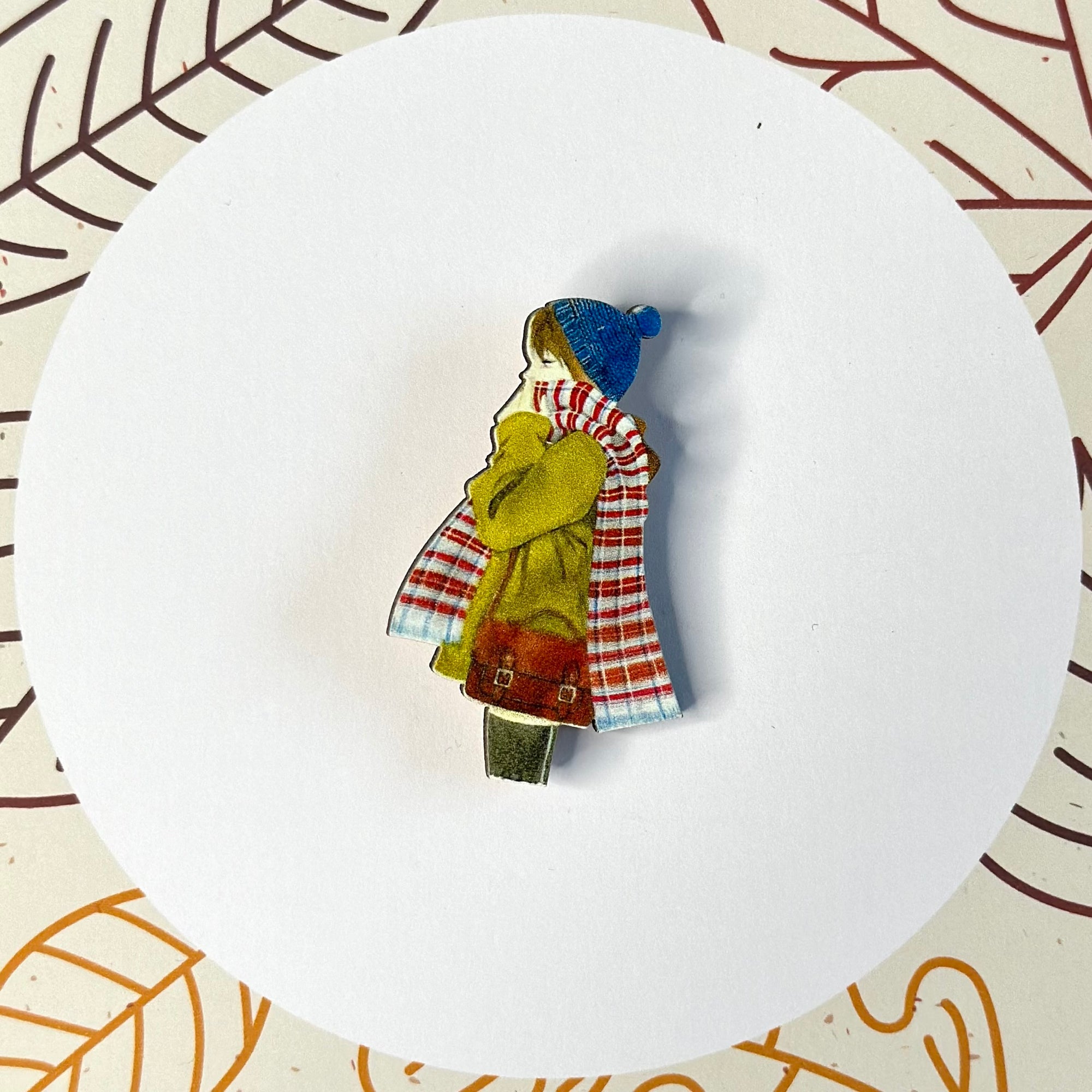 A girl with a colorful scarf and a bag with a wooden brooch