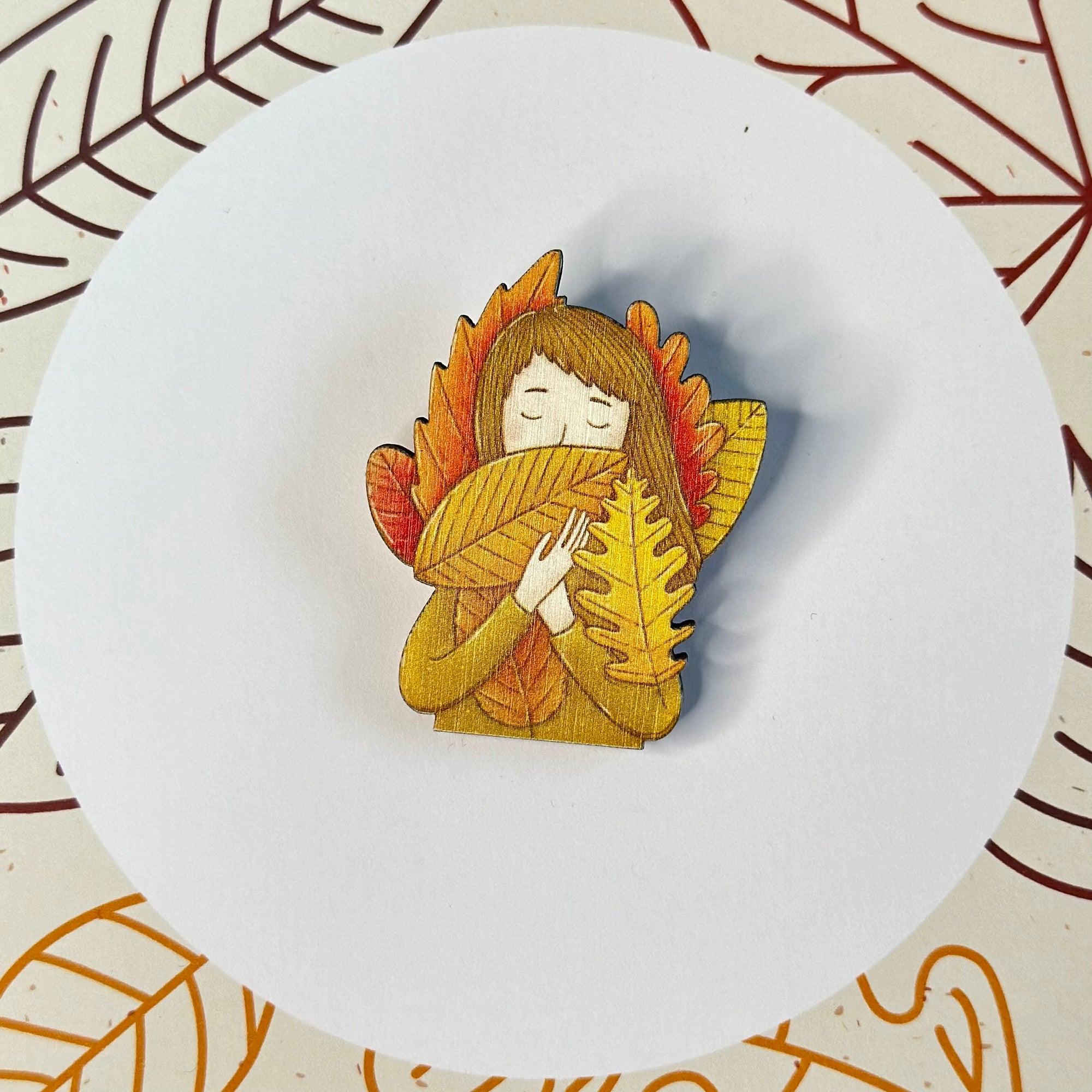 A girl with leaves on a wooden brooch