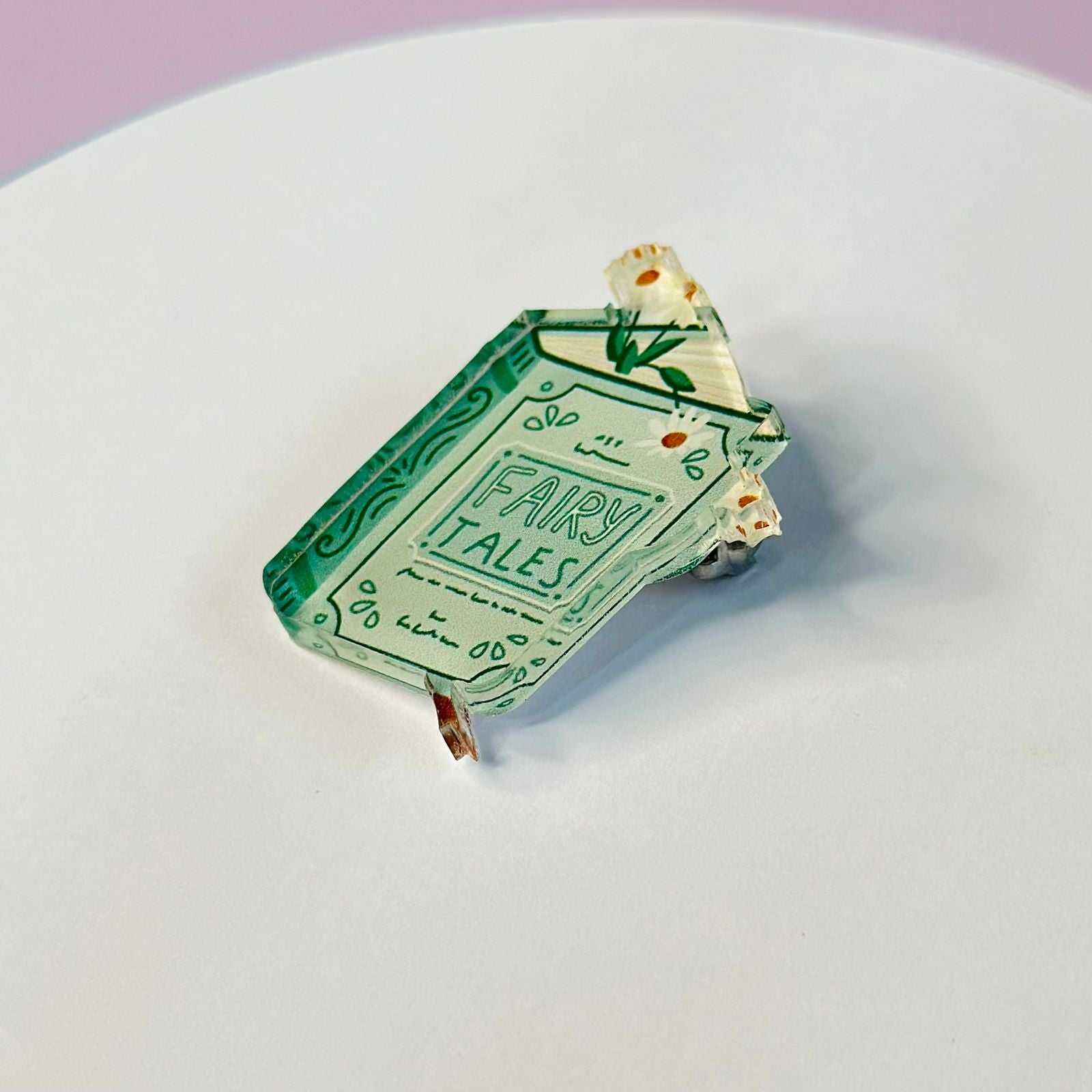 The book of fairy tales is a glass brooch